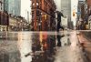 man using umbrella crossing the street during daytime